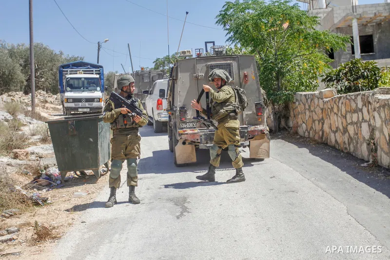 Israeli soldiers inspect the place where Jewish settlers wrote slogans against Palestinians in the Hebrew language in the village of Marda, south of the city of Nablus in the West Bank on August 24, 2022. In the early ho...