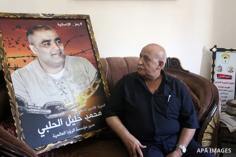 Family of World Vision's head Palestinian Mohammed al-Halabi, watch his picture on a phone after he was sentenced 12 years in prison by Israeli court, in Gaza city on August 30, 2022. An Israeli court on Tuesday sentence...