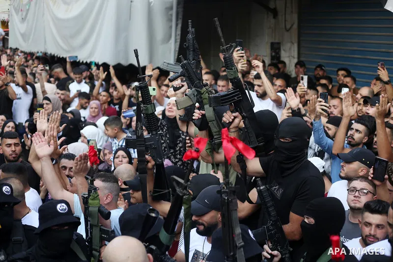 Palestinian militants hold their weapons during a memorial service of Mohammed al-Azizi and Abdul Rahman Sobh who were killed by Israeli forces on 24 July, in the West Bank city of Nablus on September 2, 2022. Photo by S...