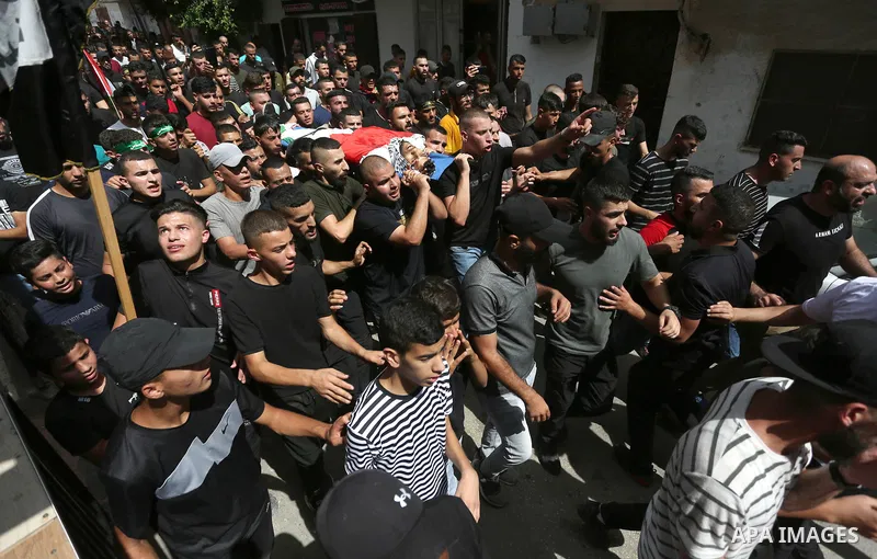 Palestinians carry the body of Younes Tayeh , 21, was killed after Israeli forces directly shot him in the heart during a military raid during his funeral in the refugee camp of al-Fara'a, south of the West Bank city of...