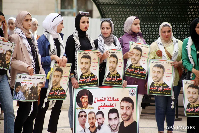 Students from Palestine Polytechnic hold placards during a protest in solidarity with a cancer sick prisoner Nasser Abu Hamid, in the West Bank city of Hebron on September 20, 2022. Palestinian Prisoner Society (PPS) sai...