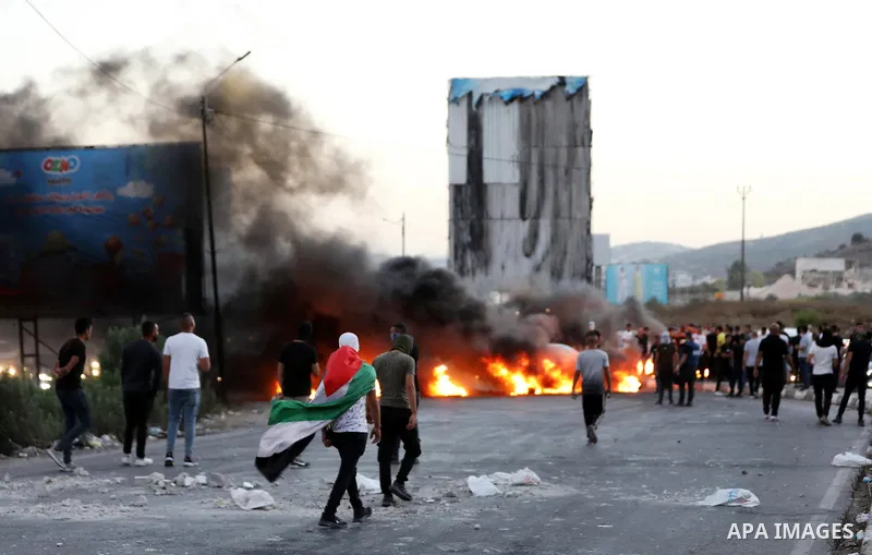 Youths burn tires during a protest against the killing of 4 Palestinians by Israeli forces near Hawara military checkpoint, in the West Bank city of Nablus on September 28, 2022. An Israeli raid targeting alleged militan...