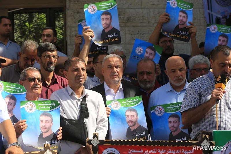 Palestinians take part in a protest in solidarity with a cancer sick prisoner Nasser Abu Hamid at Israeli jails, in front of Red Cross office in Gaza city on September 29, 2022. Hundreds of Palestinians marched today dem...