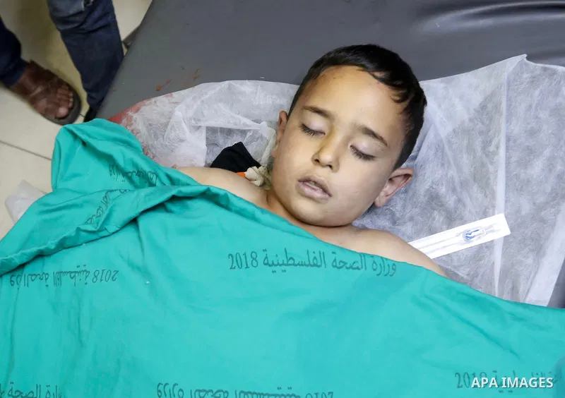 Relatives of a Palestinian child who was dead after falling from a high place while running away from Israeli soldiers near Bethlehem, mourn over his body at a hospital in the West Bank on September 29, 2022. Photo by WA...
