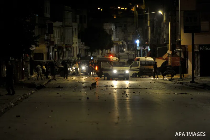 A police vehicle is stationed in the middle of street during protesters in Ettadhamen, a working-class suburb west of the capital Tunis on October 14, 2022, the day after a 24-year-old man from Upper El Omrane died in ho...