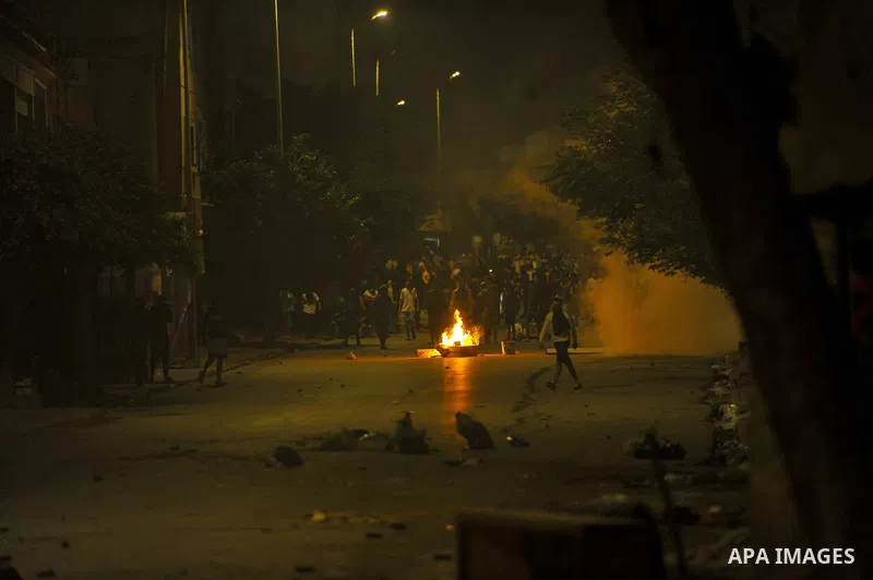 Protestors throw rocks at security forces in Ettadhamen, a working-class suburb west of the capital Tunis on October 14, 2022, the day a 24-year-old man from Upper El Omrane died in hosptal from injuries sustained in lat...