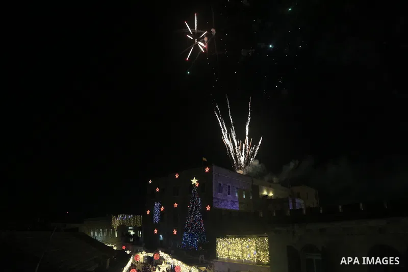 Palestinians gather during the Christmas tree lighting at the Jaffa Gate of the old city of Jerusalem on December 11, 2022. Photo by Saeed Qaq\ apaimages