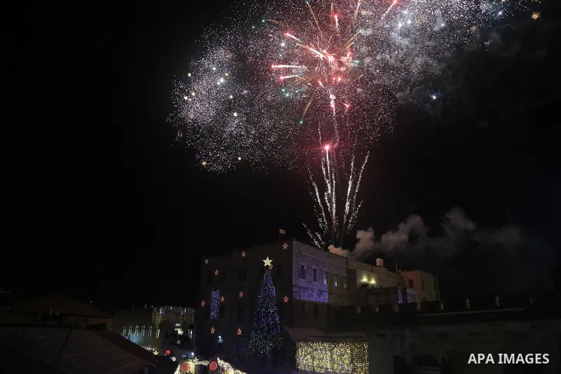 Palestinians gather during the Christmas tree lighting at the Jaffa Gate of the old city of Jerusalem on December 11, 2022. Photo by Saeed Qaq\ apaimages