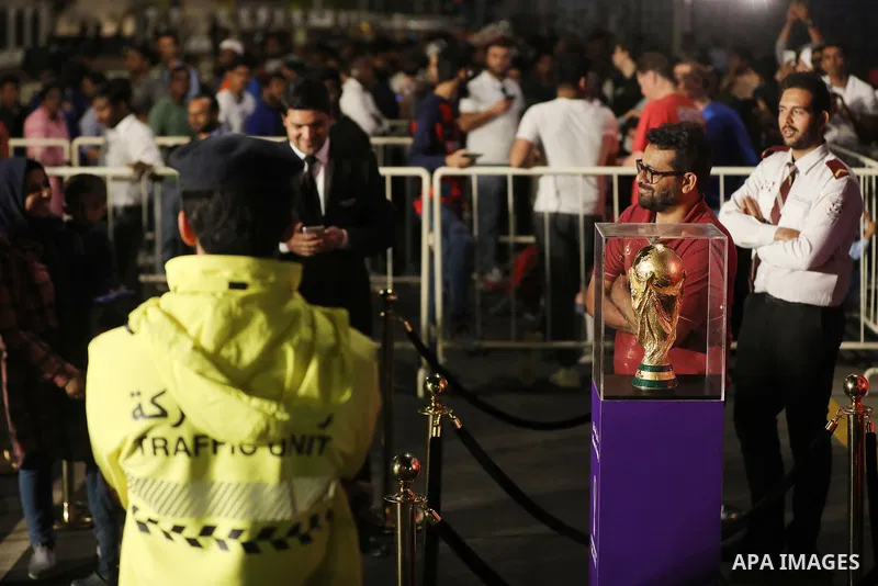 Football fans take photo with original version of World trophy during the FIFA World Cup Qatar 2022 on the Doha Corniche, in Qatar on December 15, 2022. The 2022 FIFA World Cup is an association football tournament, cont...