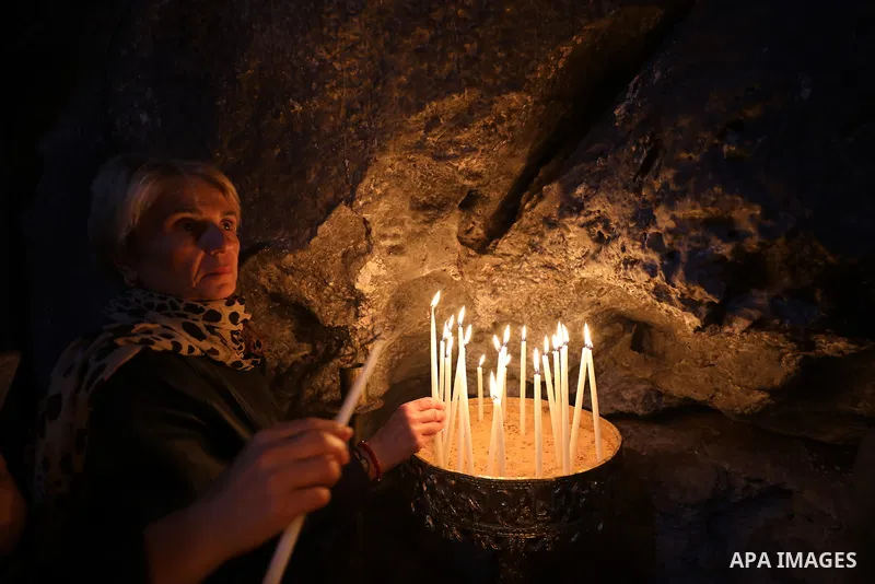 Christian worshippers light candles at the Greek Orthodox Church of Saint Barbara on the eve of Saint Barbara's Day, in the village of Aboud in the village of Aboud in the West Bank, on December 16, 2022, on the eve of S...