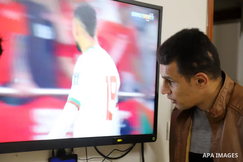 Palestinians listen to TV during the match between Morocco VS Canada, in the Qatar World Cup FIFA 2022, in Gaza city on December 1, 2022. There are at least 130,000 Palestinian people aged 50 years and older who live wit...