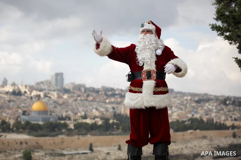 Palestinian Issa Kassissieh, dressed as Santa Claus, poses for a picture at the Mount of Olives in Jerusalem, a few weeks before the upcoming holiday of Christmas on December 6, 2022. In Jerusalem's Old City there are do...