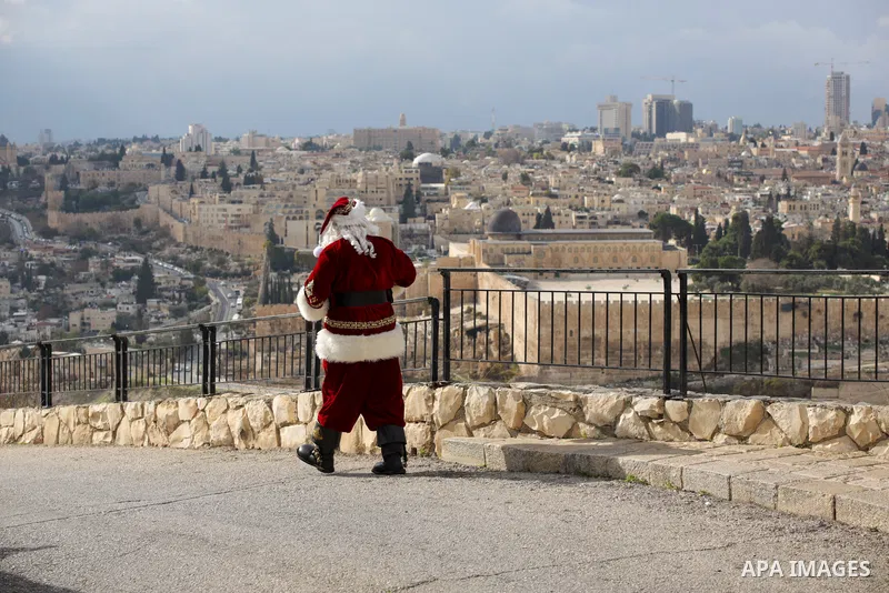 Palestinian Issa Kassissieh, dressed as Santa Claus, poses for a picture at the Mount of Olives in Jerusalem, a few weeks before the upcoming holiday of Christmas on December 6, 2022. In Jerusalem's Old City there are do...