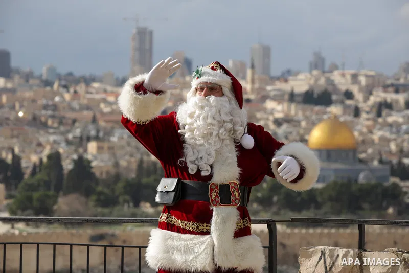 Palestinian Issa Kassissieh, dressed as Santa Claus, poses for a picture at the Mount of Olives in Jerusalem, a few weeks before the upcoming holiday of Christmas on December 6, 2022. In Jerusalem's Old City there are do...