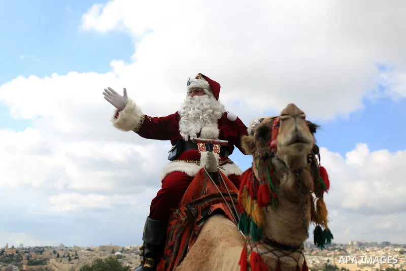 Palestinian Issa Kassissieh, dressed as Santa Claus, poses for a picture as he rides a camel at the Mount of Olives in Jerusalem, a few weeks before the upcoming holiday of Christmas on December 6, 2022. In Jerusalem's O...
