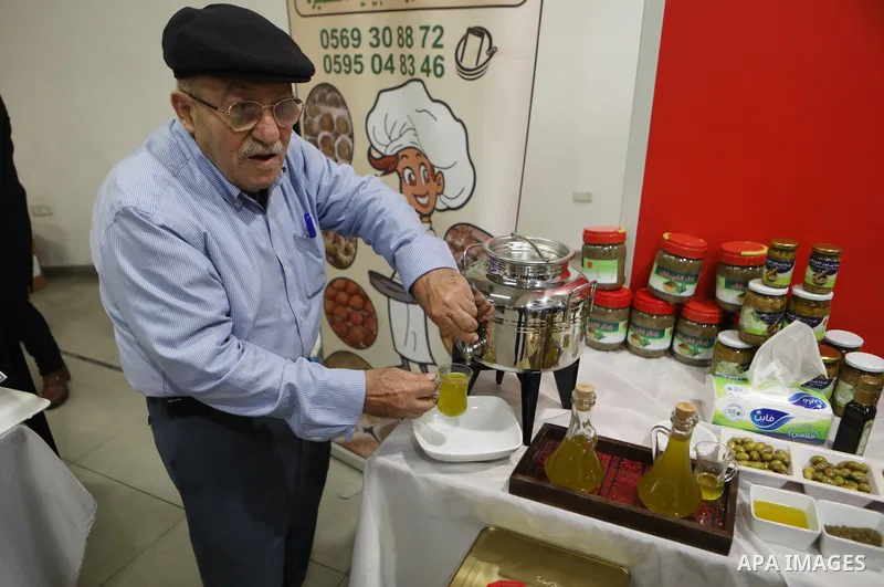 Palestinians attend the Third National Olive Festival in the West Bank city of Hebron on December 10, 2022. The olive harvest is a main source of income for thousands of Palestinian households. Photo by Mamoun Wazwaz
