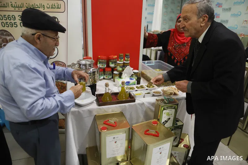 Palestinians attend the Third National Olive Festival in the West Bank city of Hebron on December 10, 2022. The olive harvest is a main source of income for thousands of Palestinian households. Photo by Mamoun Wazwaz