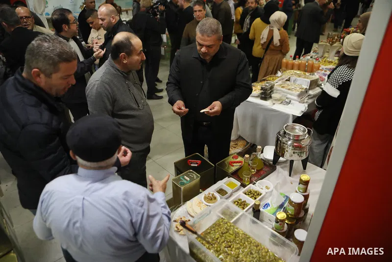 Palestinians attend the Third National Olive Festival in the West Bank city of Hebron on December 10, 2022. The olive harvest is a main source of income for thousands of Palestinian households. Photo by Mamoun Wazwaz