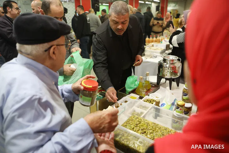Palestinians attend the Third National Olive Festival in the West Bank city of Hebron on December 10, 2022. The olive harvest is a main source of income for thousands of Palestinian households. Photo by Mamoun Wazwaz