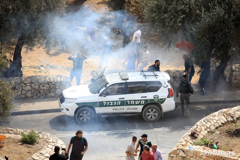 Palestinians argue with Israeli policemen who prevent them picking olives in the Arab neighbourhood of Silwan in Israel-annexed eastern Jerusalem amid Israeli calls for the control of Arab lands and olive picking by sett...