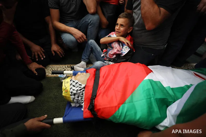 The son of Palestinian Mojahed Dawood 30, who died of a wound he sustained during clashes with Israeli forces, mourns during his funeral in West Bank city of Salfit on October 16, 2022. Photo by Wajed Nobani