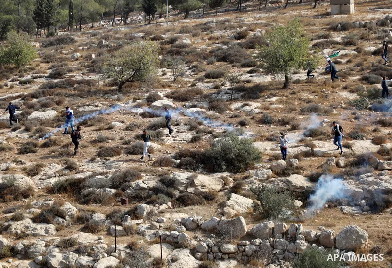 Israeli forces shoot tear gas at Palestinian during a campaign to harvest olive, in Masafer Yatta near the West Bank city of Hebron October 22, 2022. The olive harvest is a national holiday and a main source of income fo...