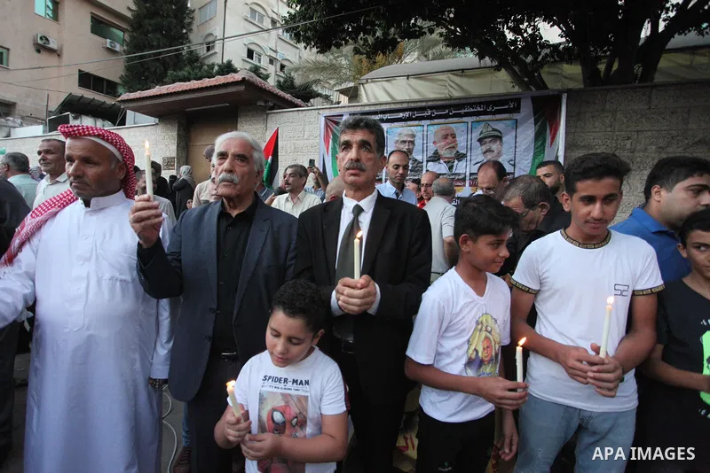 Palestinians hold banners and light candles during a protest in solidarity with Palestinian prisoner in Israeli jails suffering from cancer Nasser Abu Hamid, in front of Red cross office, in Gaza city on September 13, 20...