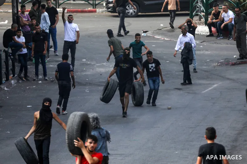 Palestinian protesters hurl stones towards Israeli forces following a demonstration against settlements, in the West Bank city of Hebron on August 12, 2022. Photo by Mamoun Wazwaz