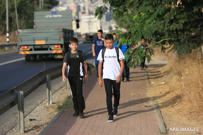 Palestinian students walk to their schools of the first day of the new year study, in al-Lubban al-Sharqiya village, south of Nablus city, in the West Bank on August 29, 2022. Attacks on education by Israeli military for...