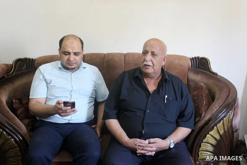 Family of World Vision's head Palestinian Mohammed al-Halabi, watch his picture on a phone after he was sentenced 12 years in prison by Israeli court, in Gaza city on August 30, 2022. An Israeli court on Tuesday sentence...