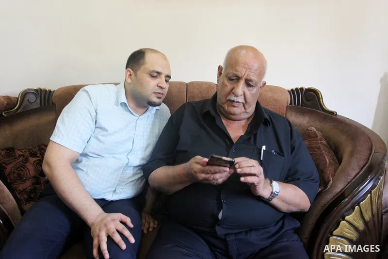 Family of World Vision's head Palestinian Mohammed al-Halabi, watch his picture on a phone after he was sentenced 12 years in prison by Israeli court, in Gaza city on August 30, 2022. An Israeli court on Tuesday sentence...