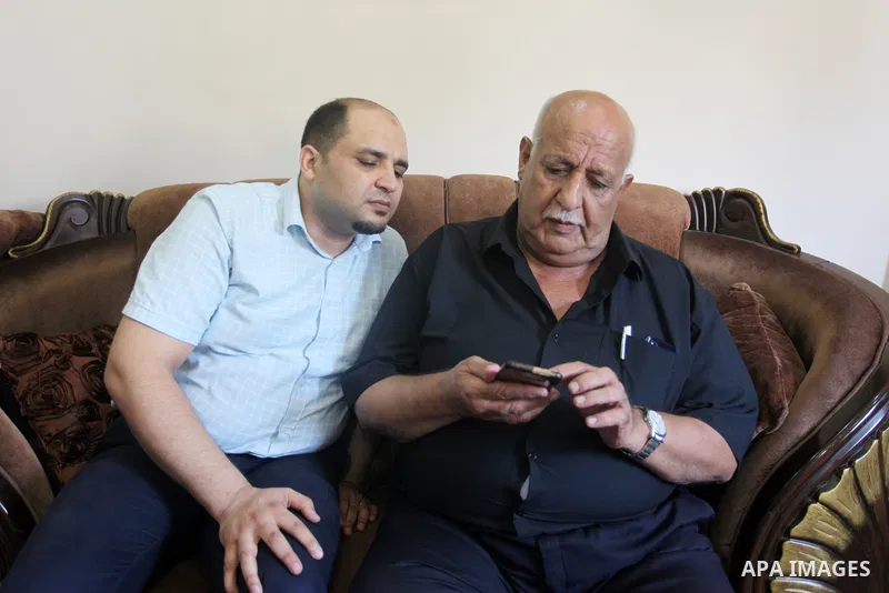 Family of World Vision's head Palestinian Mohammed al-Halabi, watch his picture on a phone after he was sentenced 12 years in prison by Israeli court, in Gaza city on August 30, 2022. An Israeli court on Tuesday sentence...