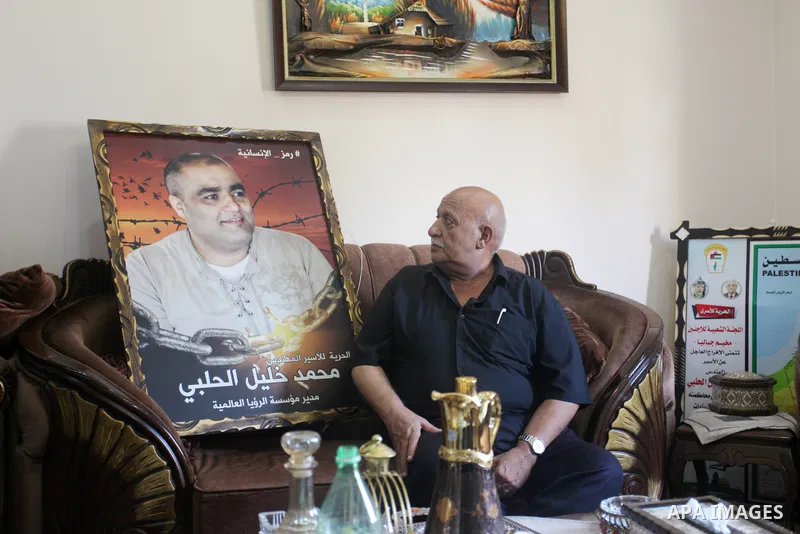 Family of World Vision's head Palestinian Mohammed al-Halabi, watch his picture on a phone after he was sentenced 12 years in prison by Israeli court, in Gaza city on August 30, 2022. An Israeli court on Tuesday sentence...