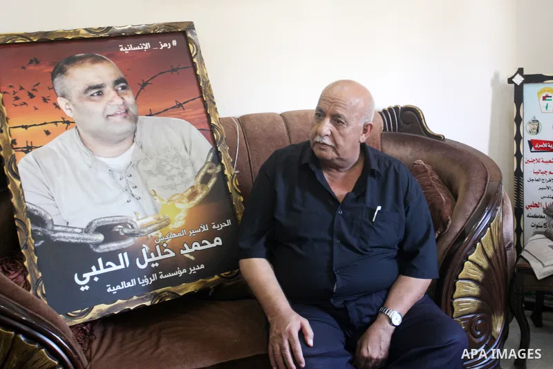 Family of World Vision's head Palestinian Mohammed al-Halabi, watch his picture on a phone after he was sentenced 12 years in prison by Israeli court, in Gaza city on August 30, 2022. An Israeli court on Tuesday sentence...