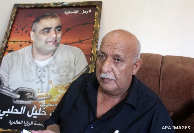 Family of World Vision's head Palestinian Mohammed al-Halabi, watch his picture on a phone after he was sentenced 12 years in prison by Israeli court, in Gaza city on August 30, 2022. An Israeli court on Tuesday sentence...