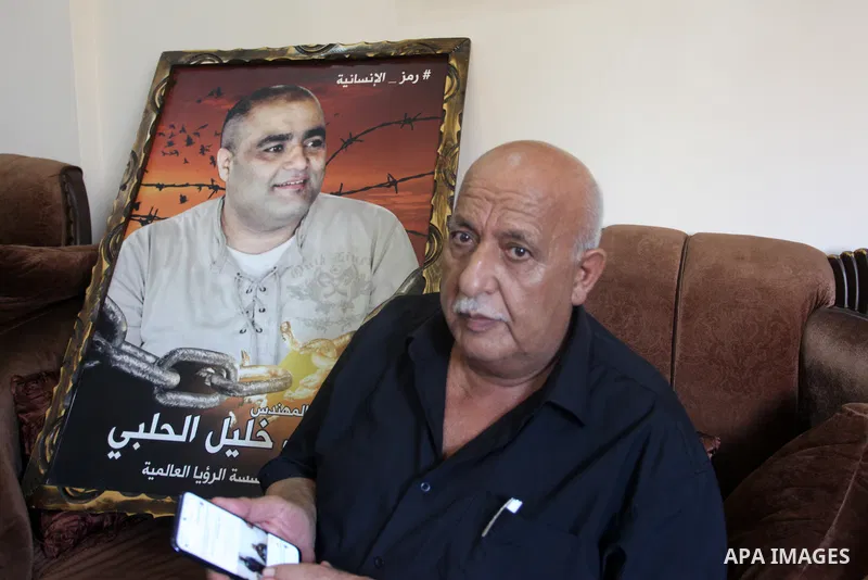 Family of World Vision's head Palestinian Mohammed al-Halabi, watch his picture on a phone after he was sentenced 12 years in prison by Israeli court, in Gaza city on August 30, 2022. An Israeli court on Tuesday sentence...