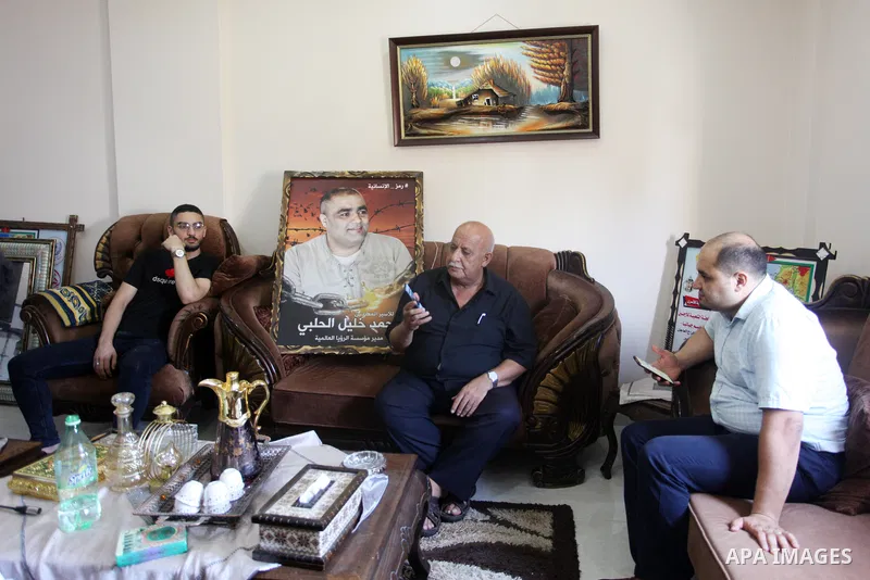 Family of World Vision's head Palestinian Mohammed al-Halabi, watch his picture on a phone after he was sentenced 12 years in prison by Israeli court, in Gaza city on August 30, 2022. An Israeli court on Tuesday sentence...