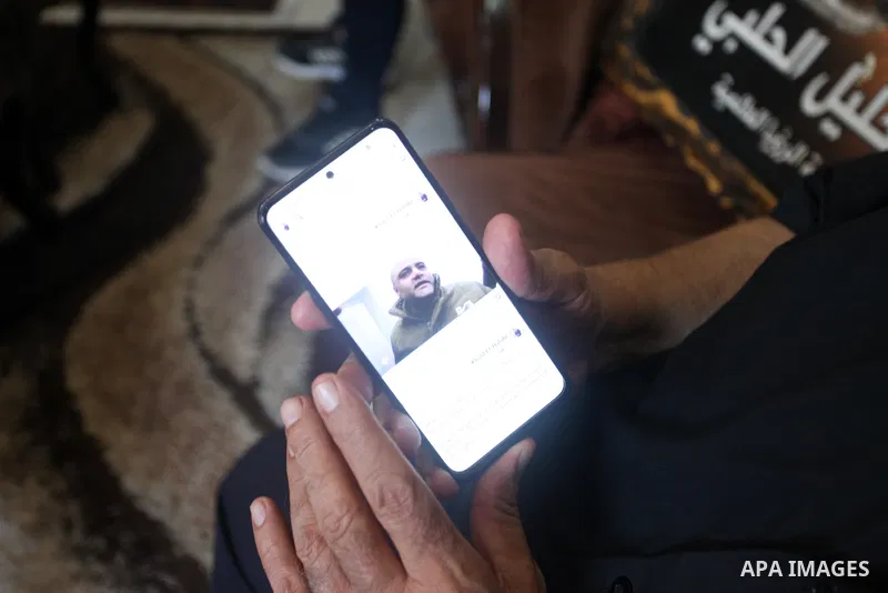 Family of World Vision's head Palestinian Mohammed al-Halabi, watch his picture on a phone after he was sentenced 12 years in prison by Israeli court, in Gaza city on August 30, 2022. An Israeli court on Tuesday sentence...