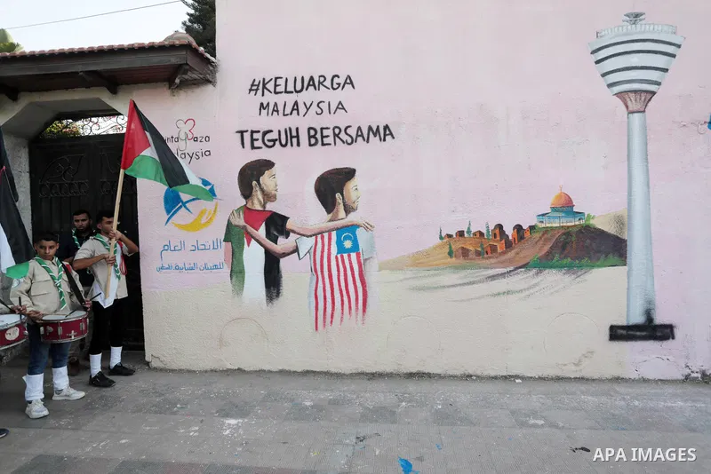 Palestinians attend the opening of a mural on the occasion of Malaysian National Day, in Gaza City on August 30, 2022. Malaysia's Independence Day is celebrated on August 31st. Also known as Merdeka Day (Freedom Day), th...