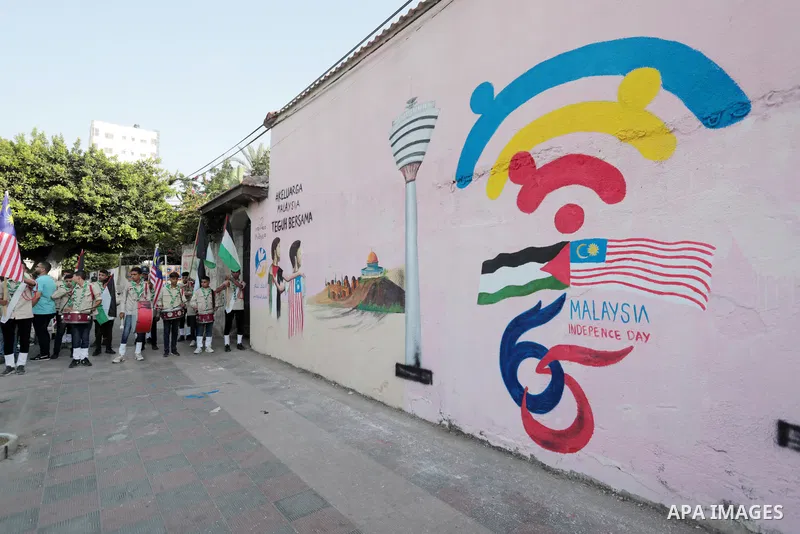 Palestinians attend the opening of a mural on the occasion of Malaysian National Day, in Gaza City on August 30, 2022. Malaysia's Independence Day is celebrated on August 31st. Also known as Merdeka Day (Freedom Day), th...