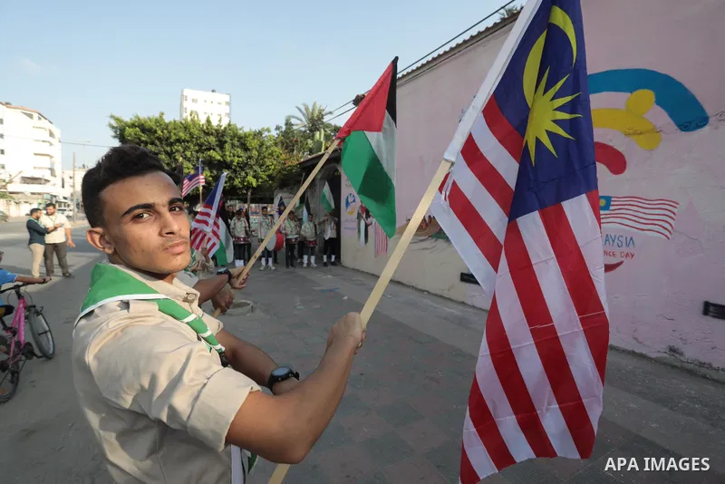 Palestinians attend the opening of a mural on the occasion of Malaysian National Day, in Gaza City on August 30, 2022. Malaysia's Independence Day is celebrated on August 31st. Also known as Merdeka Day (Freedom Day), th...