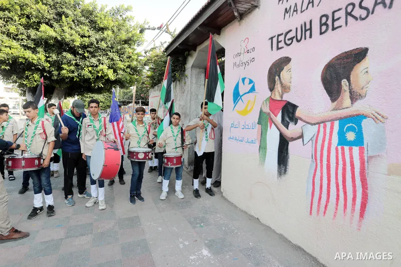 Palestinians attend the opening of a mural on the occasion of Malaysian National Day, in Gaza City on August 30, 2022. Malaysia's Independence Day is celebrated on August 31st. Also known as Merdeka Day (Freedom Day), th...