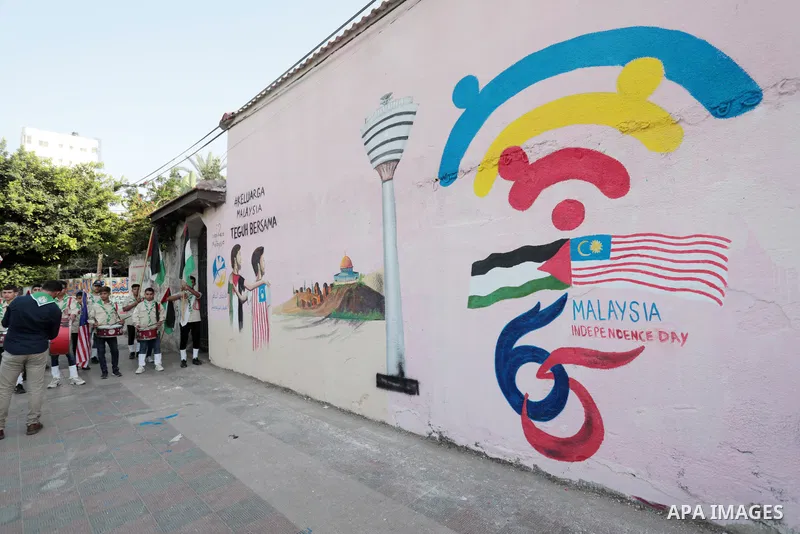 Palestinians attend the opening of a mural on the occasion of Malaysian National Day, in Gaza City on August 30, 2022. Malaysia's Independence Day is celebrated on August 31st. Also known as Merdeka Day (Freedom Day), th...