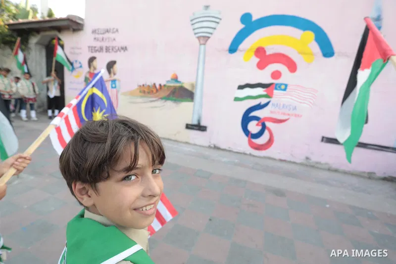 Palestinians attend the opening of a mural on the occasion of Malaysian National Day, in Gaza City on August 30, 2022. Malaysia's Independence Day is celebrated on August 31st. Also known as Merdeka Day (Freedom Day), th...