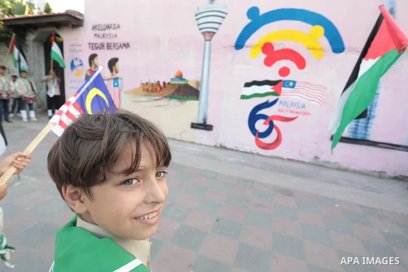 Palestinians attend the opening of a mural on the occasion of Malaysian National Day, in Gaza City on August 30, 2022. Malaysia's Independence Day is celebrated on August 31st. Also known as Merdeka Day (Freedom Day), th...