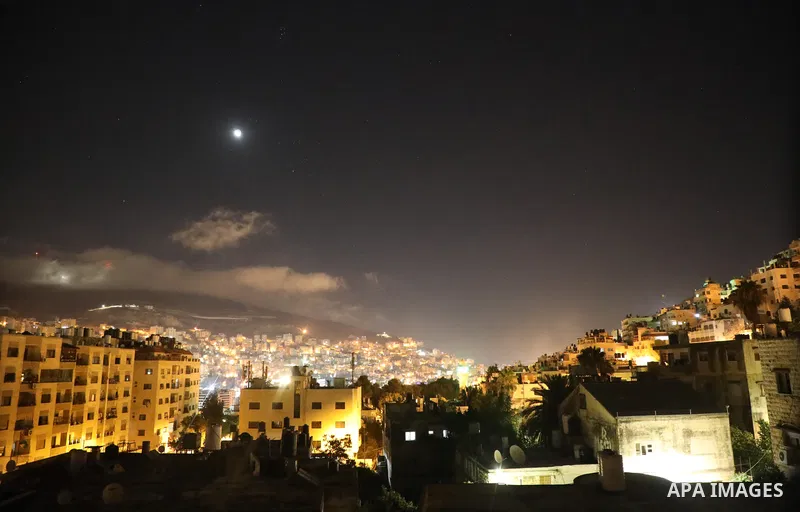 Smoke rises from a home of Palestinian Mohammad Al-Azizi during an Israeli military operation in the West Bank city of Nablus on July 24, 2022. Israeli troops killed Two Palestinian civilian in the West Bank, the Palesti...