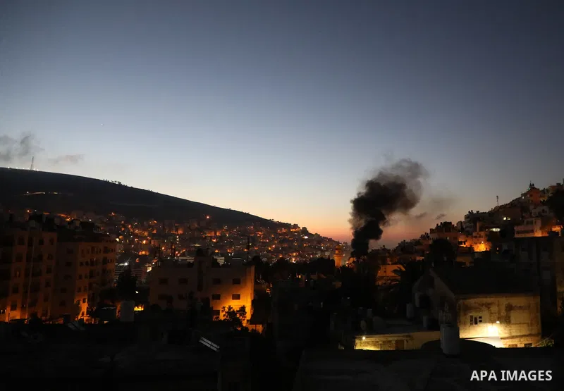 Smoke rises from a home of Palestinian Mohammad Al-Azizi during an Israeli military operation in the West Bank city of Nablus on July 24, 2022. Israeli troops killed Two Palestinian civilian in the West Bank, the Palesti...