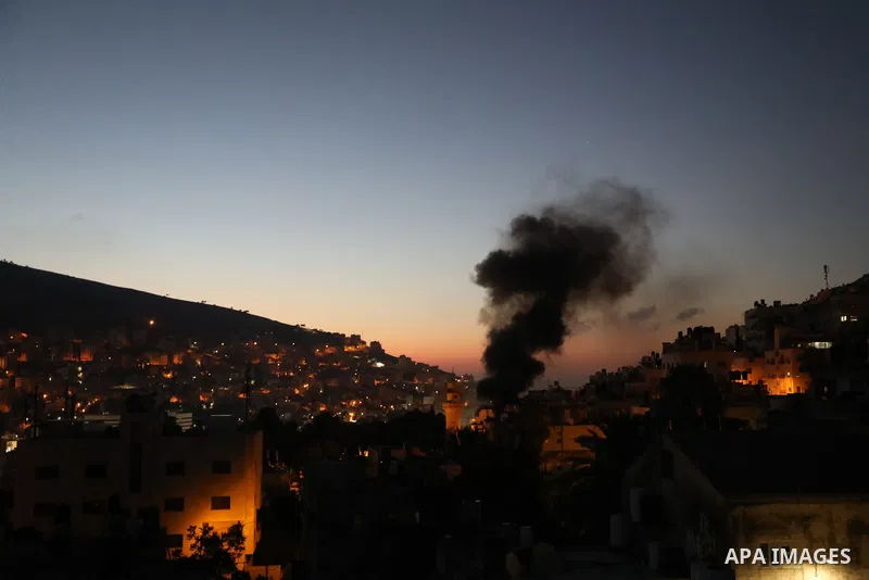 Smoke rises from a home of Palestinian Mohammad Al-Azizi during an Israeli military operation in the West Bank city of Nablus on July 24, 2022. Israeli troops killed Two Palestinian civilian in the West Bank, the Palesti...