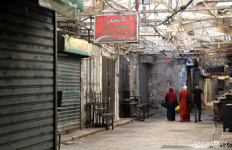 Palestinians walk near closed shops during a general strike, after Israeli forces killed Two Palestinians, in the West Bank city of Nablus on July 24, 2022. Two Palestinians were shot dead last night and ten others wound...