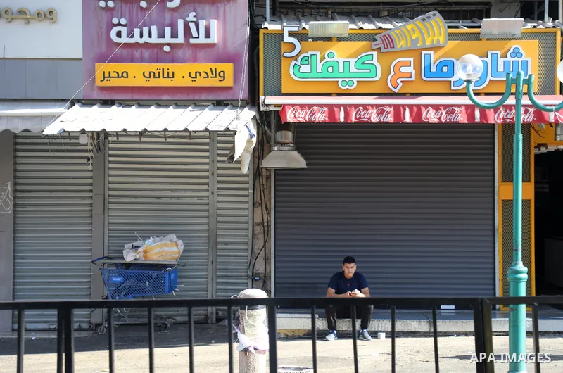 Palestinians walk near closed shops during a general strike, after Israeli forces killed Two Palestinians, in the West Bank city of Nablus on July 24, 2022. Two Palestinians were shot dead last night and ten others wound...